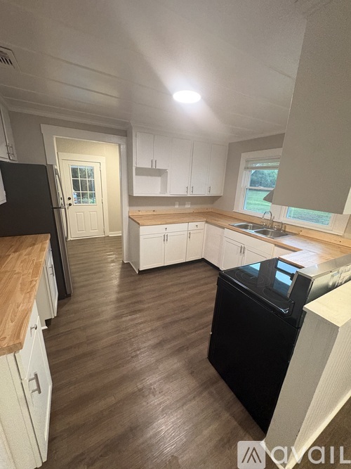 A kitchen with black appliances and white cabinets.