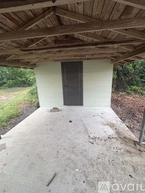 A wooden covered walkway leads to a black door.