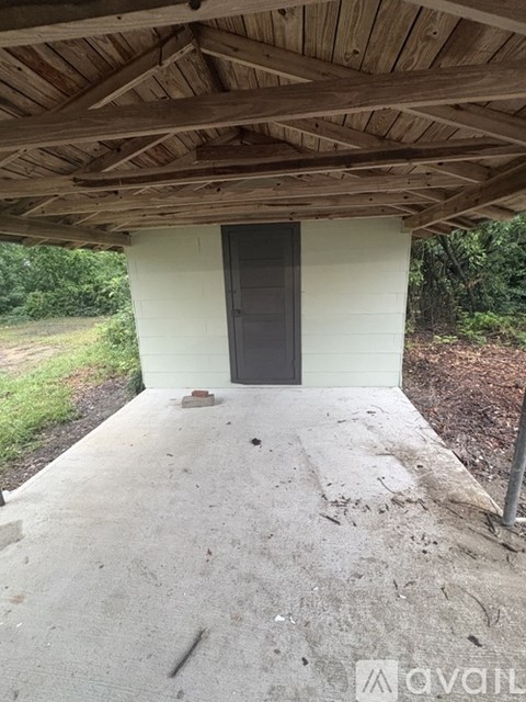 A wooden covered walkway leads to a black door.