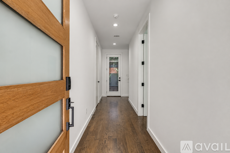 A long hallway with a wooden door on the left.