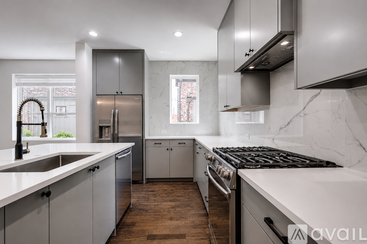 A modern kitchen with a stove top oven and a refrigerator.