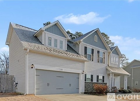 A two-story house with a garage is for sale.