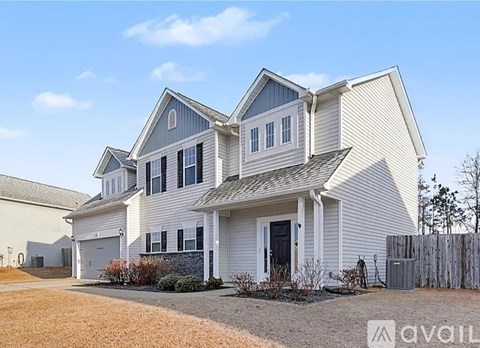 A two-story house with a garage and a driveway.