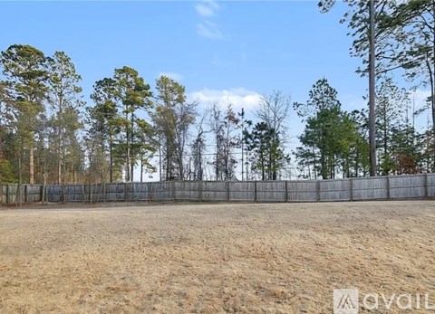 A fenced area with trees in the background.