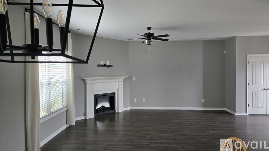 A living room with a fireplace and a ceiling fan.