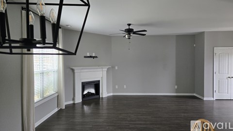 A living room with a fireplace and a ceiling fan.