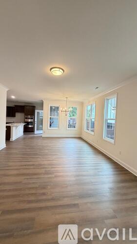 A spacious room with wooden flooring and a large window.