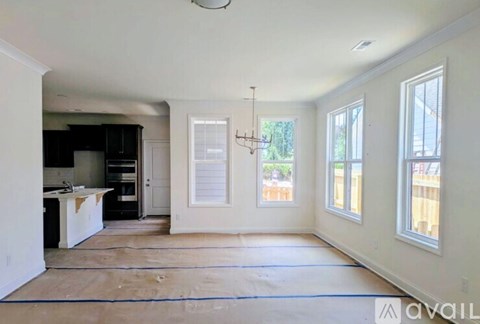 A room with a kitchen area and a dining table is available for rent.