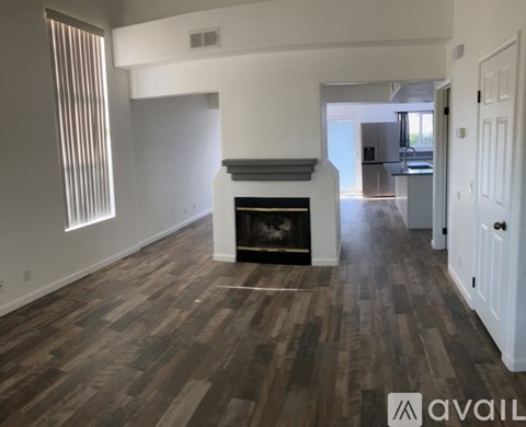 A living room with a fireplace and wood flooring.