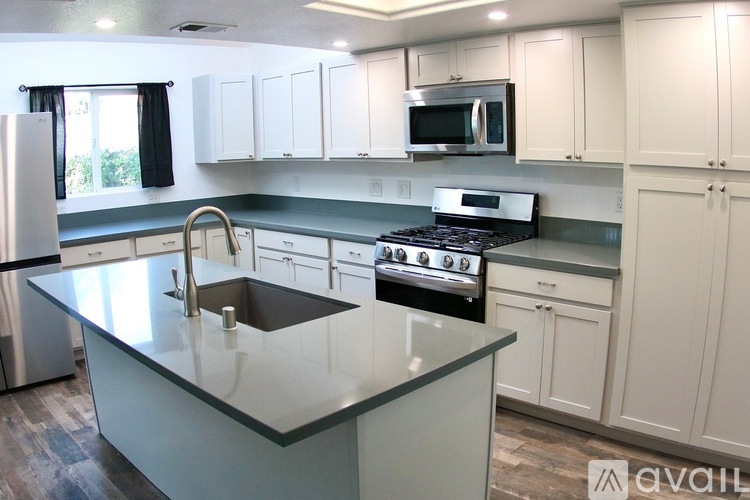 A kitchen with a granite countertop and stainless steel appliances.