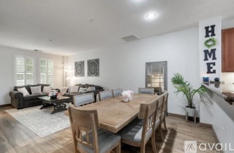 A modern dining room with a wooden table and chairs.