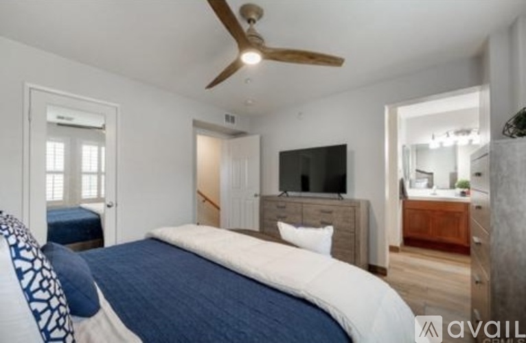 A bedroom with a large bed and a flat screen TV.