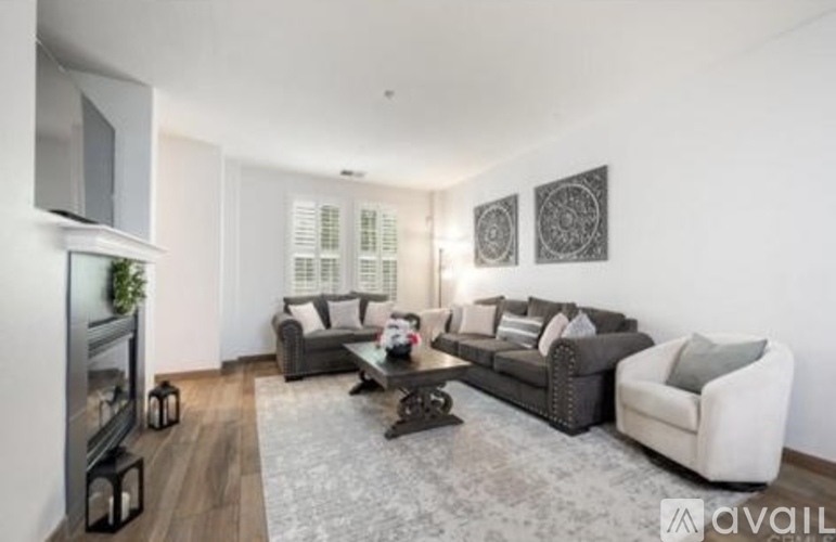 A living room with a grey couch, a white armchair, and a coffee table.