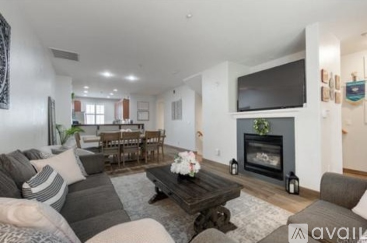 A living room with a grey couch and a fireplace.