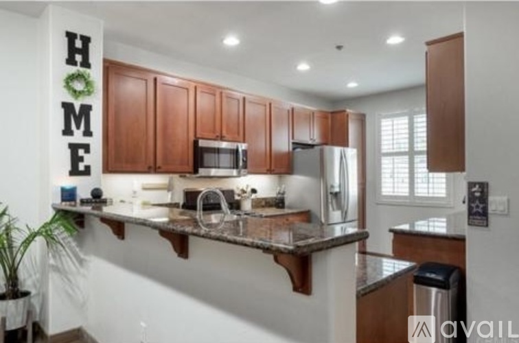 A kitchen with brown cabinets and a granite countertop.