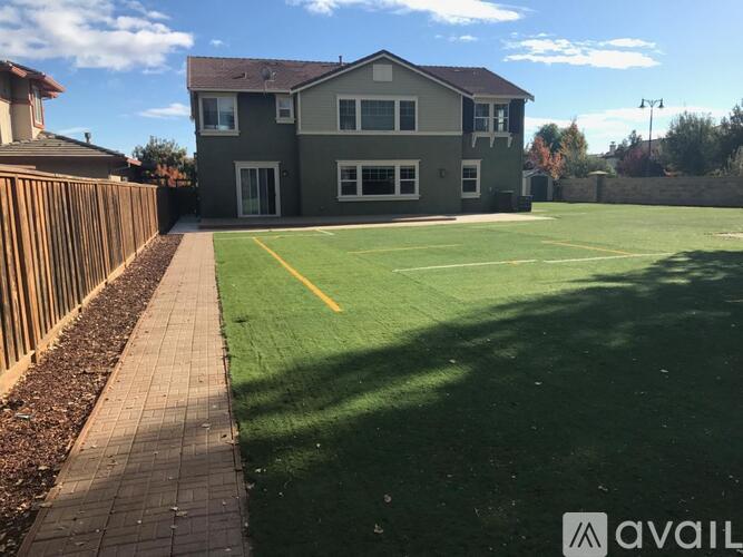 A house with a green lawn and a yellow line on the lawn.