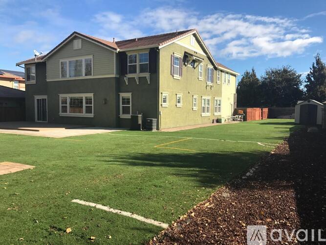 A house with a green lawn in front of it.