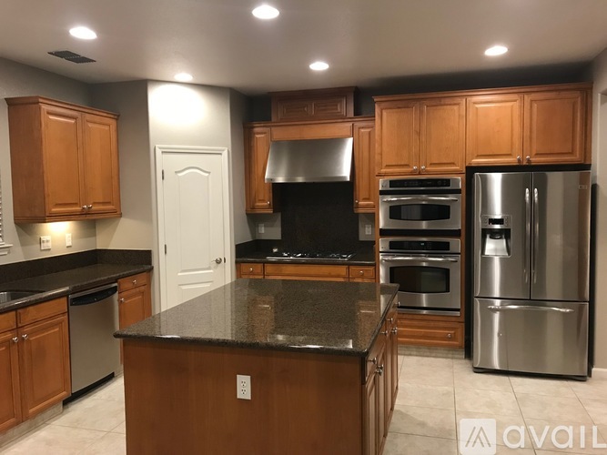 A kitchen with wooden cabinets and a black countertop.