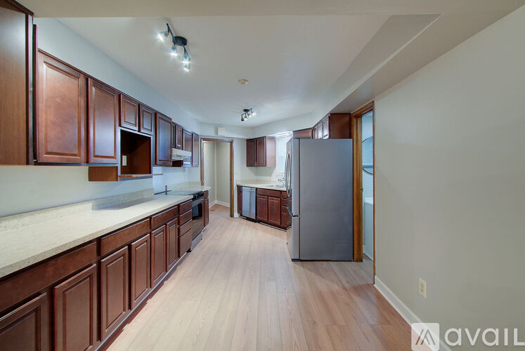 A kitchen with wooden cabinets and a refrigerator.
