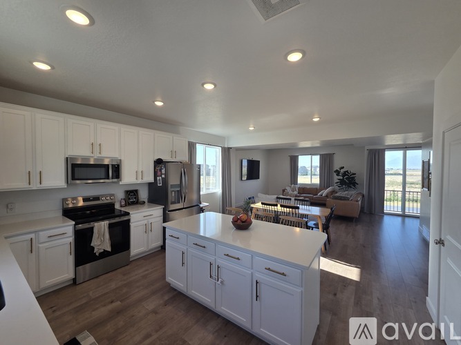 A modern kitchen with white cabinets and stainless steel appliances.