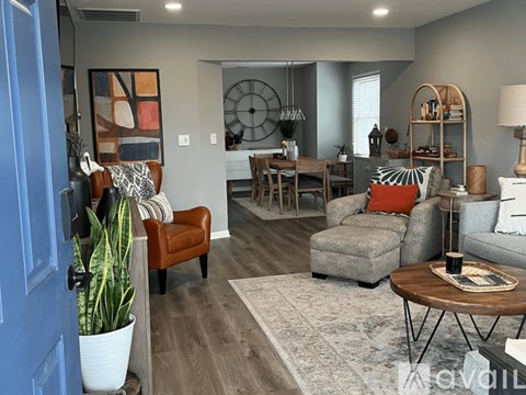 A living room with a blue door and a grey couch.