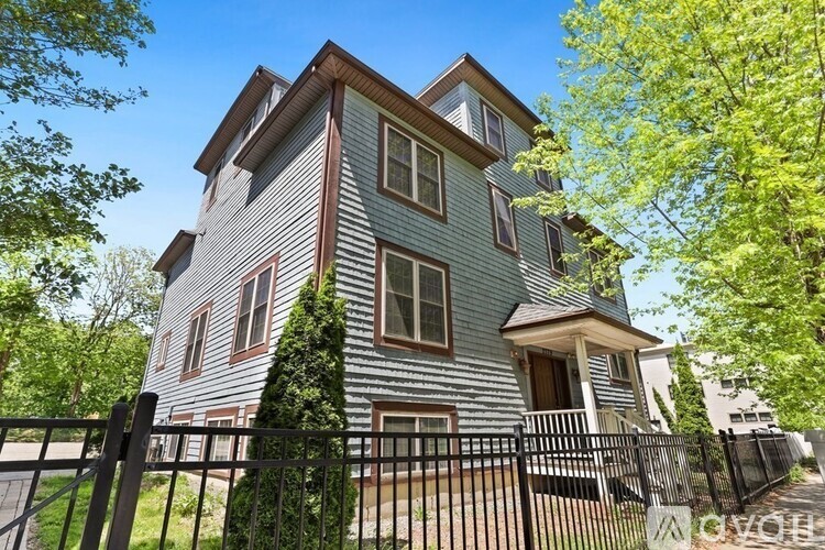A two-story house with a grey exterior and a black fence.