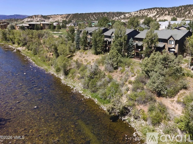 A river flows through a valley with houses on the hillside.