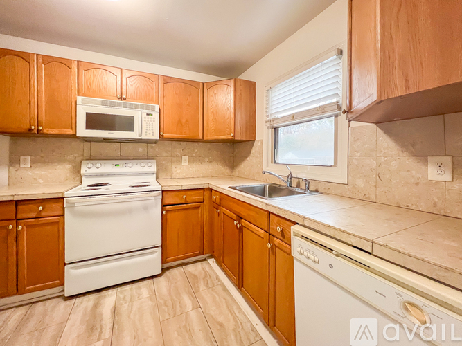 A kitchen with wooden cabinets and white appliances.