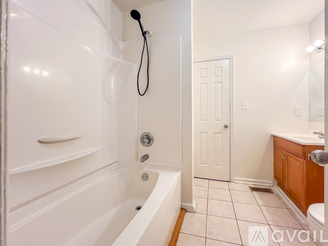 A white bathroom with a tub, sink and toilet.