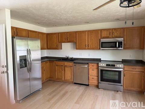 A kitchen with wooden cabinets and stainless steel appliances.