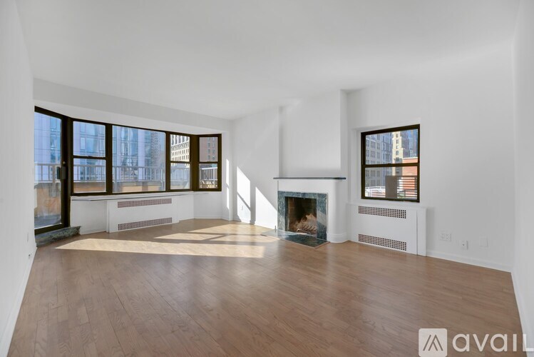 A spacious living room with a fireplace and large windows.