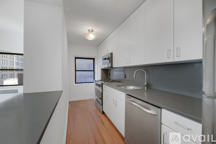 A kitchen with white cabinets and stainless steel appliances.