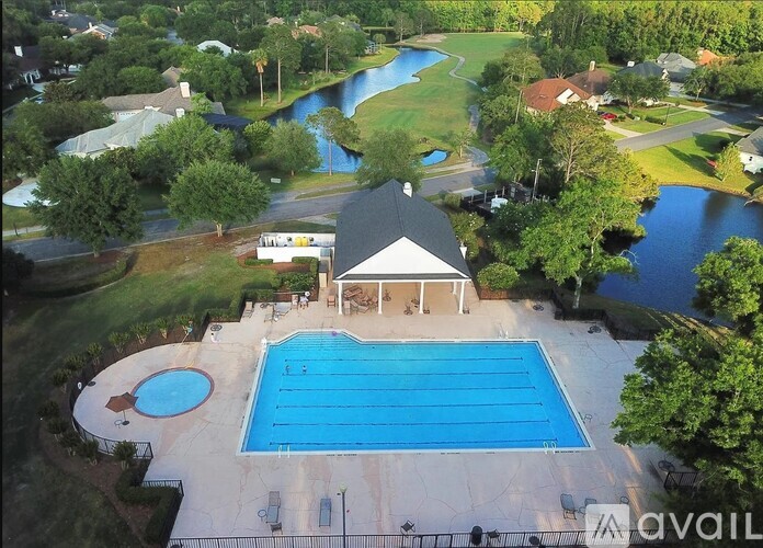 A large swimming pool with a pavilion and a waterfall in the background.