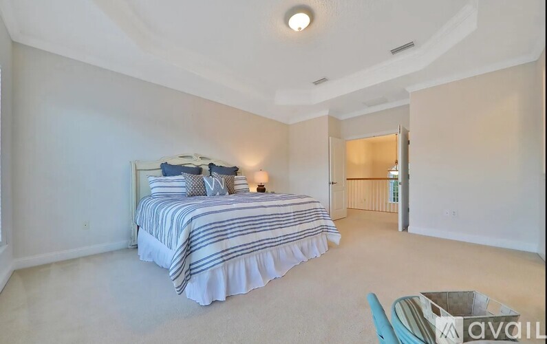 A bedroom with a bed and a chair in it.