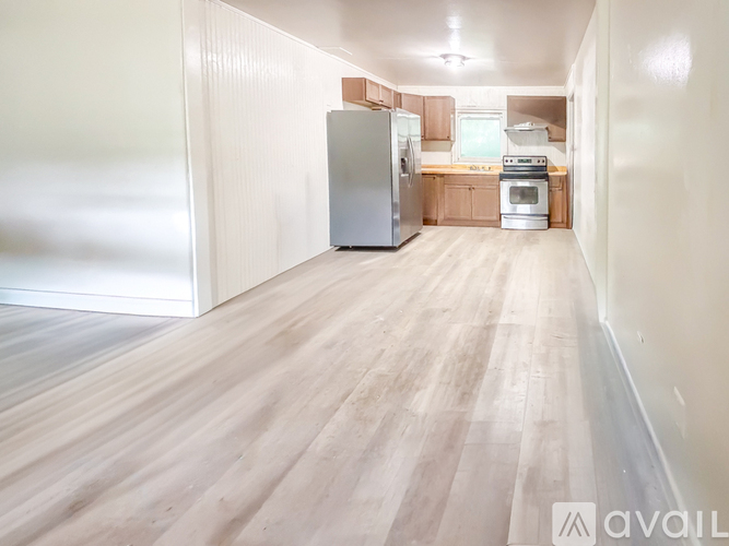 A kitchen with wooden floors and a refrigerator.