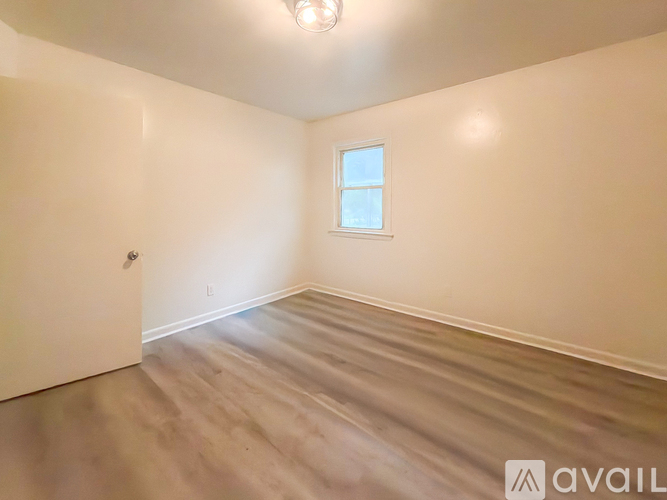 A room with a wooden floor and a window.