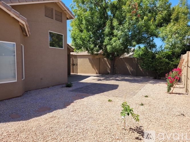 A house with a brown exterior and a gravel driveway.