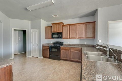 A kitchen with brown cabinets and a black stove top oven.