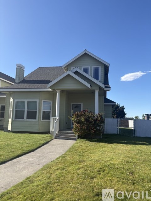 A house with a grey roof and a white fence.