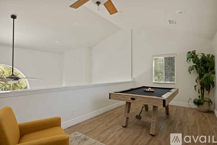 A room with a pool table and a chair.