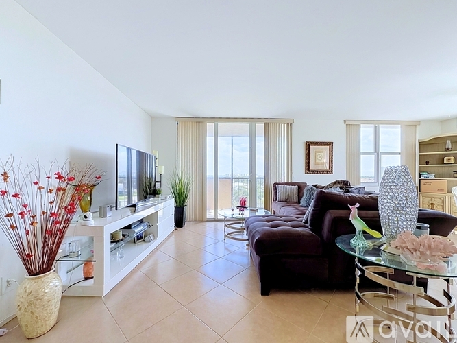 A living room with a brown couch, a glass table, and a television.