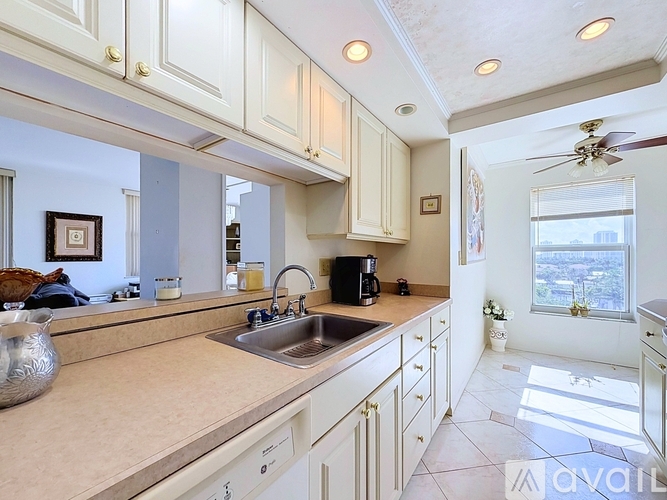 A kitchen with white cabinets and a beige countertop.
