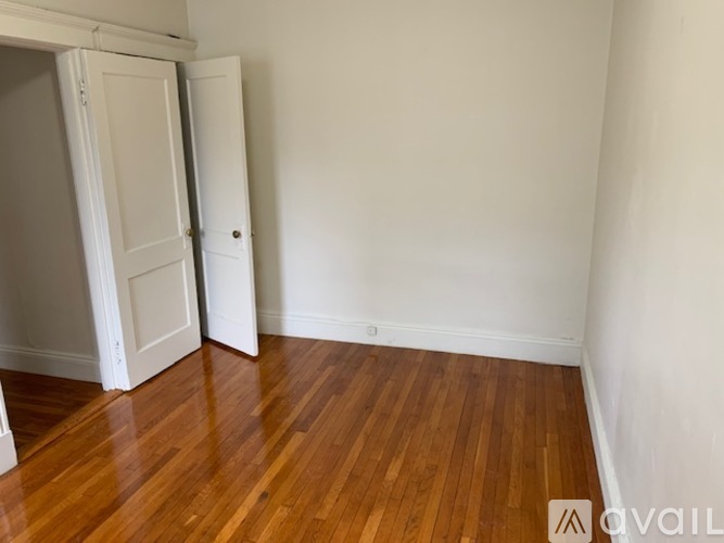 A room with a wooden floor and a white door.