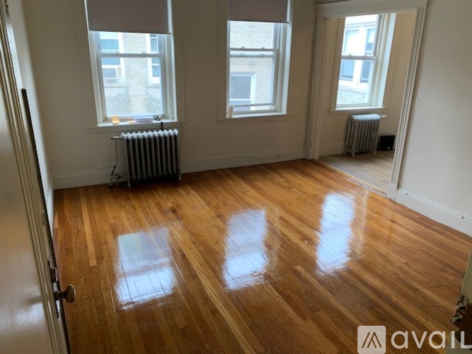A room with wooden floors and two windows.