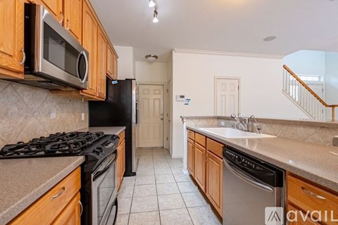 A kitchen with wooden cabinets and black appliances.