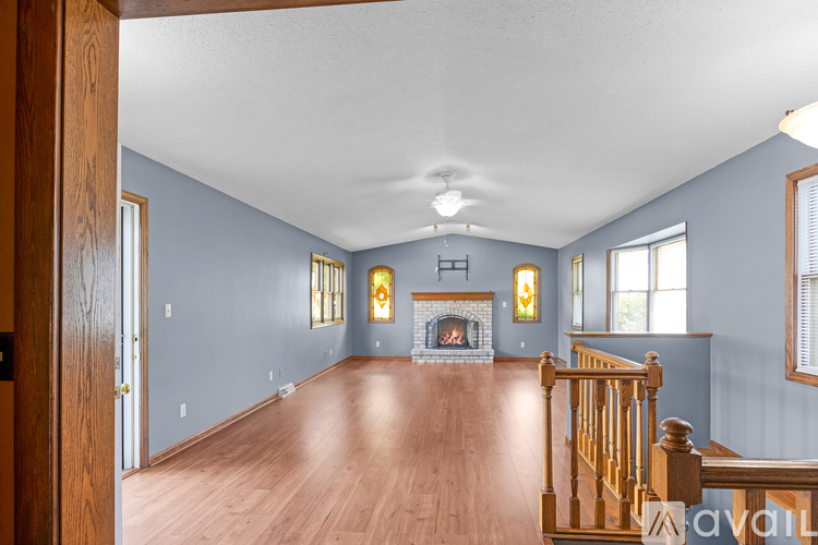 A spacious living room with a fireplace and wooden floors.