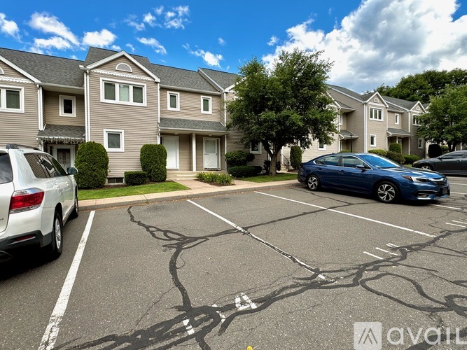A parking lot with cars and apartment buildings in the background.