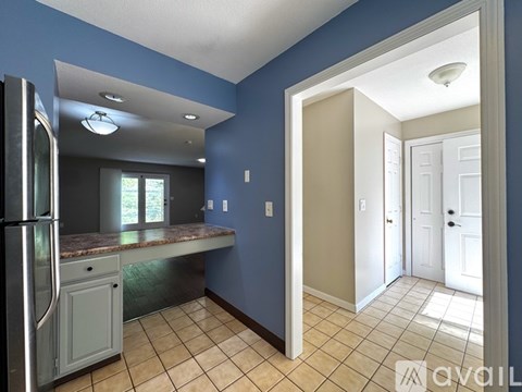 A kitchen with blue walls and a tiled floor.