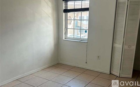A room with a window and a fan.