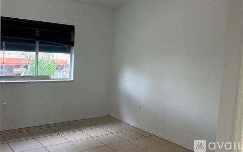 A room with a window and tiled floor.